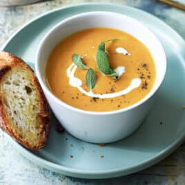 Two bowls of pumpkin soup with garnishes.