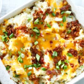 Twice baked potato casserole in a square, white casserole dish.