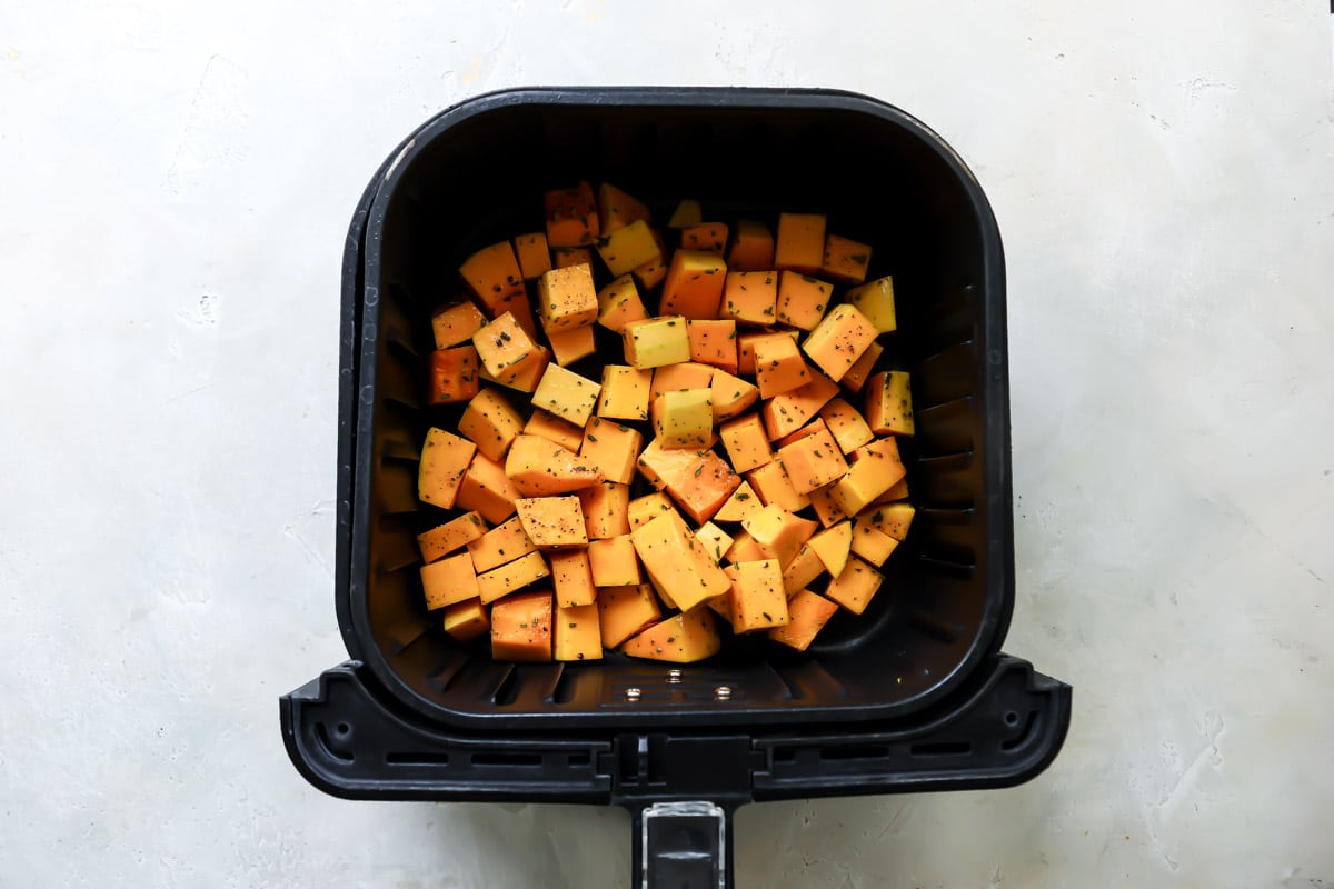 Air fryer butternut squash in an air fryer basket.