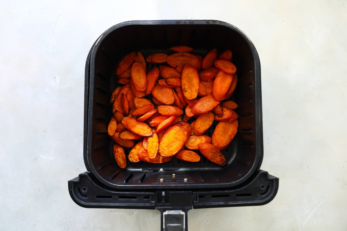 Air fryer carrots in an air fryer basket after being air fried.