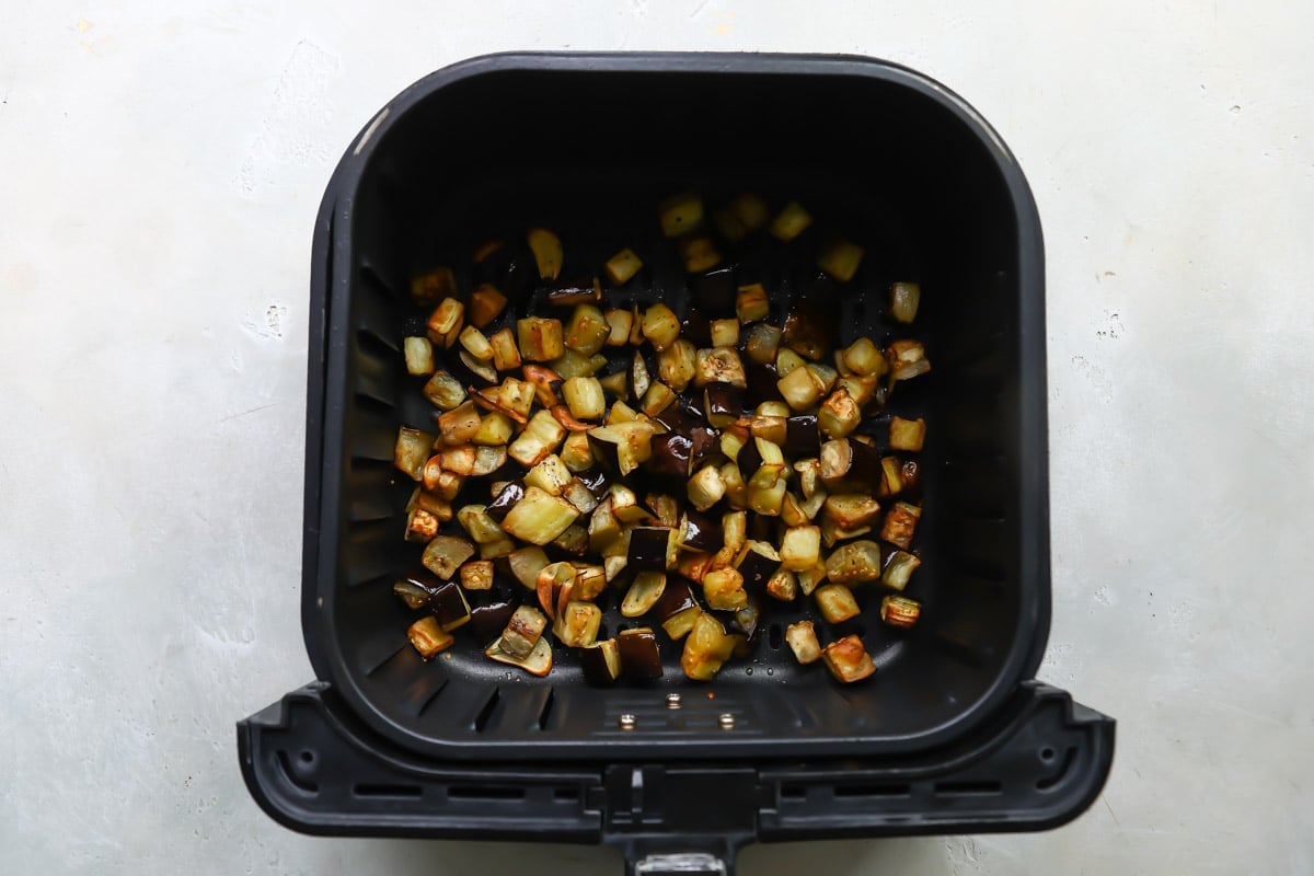 Air fried eggplant in an air fryer basket.