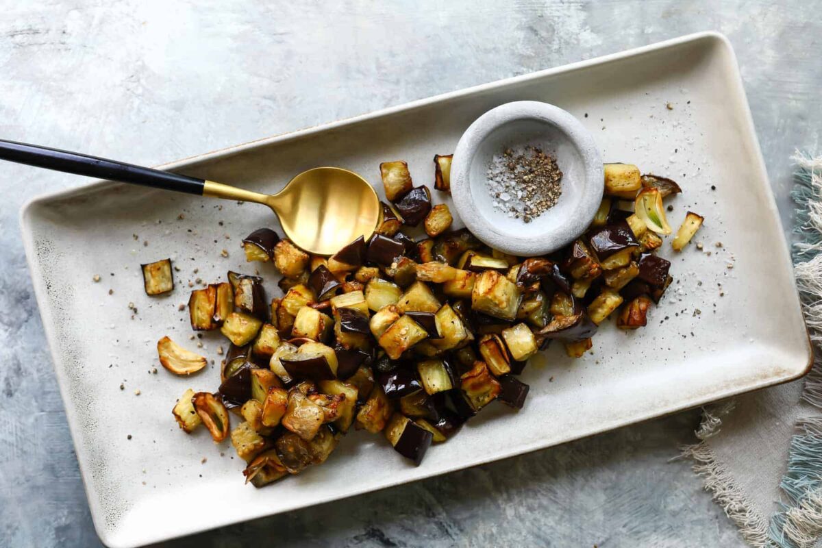 A rectangular serving platter with air fryer eggplant on it.