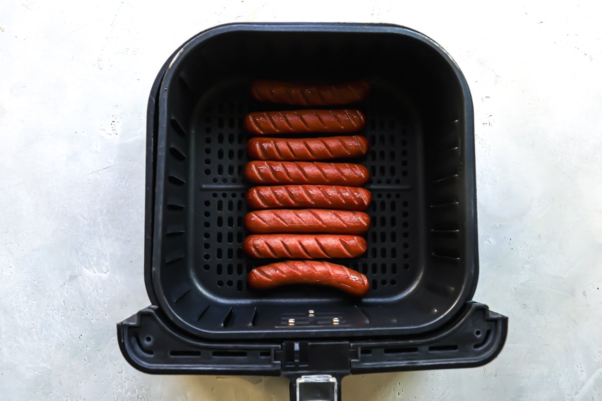 Sliced hot dogs in an air fryer.