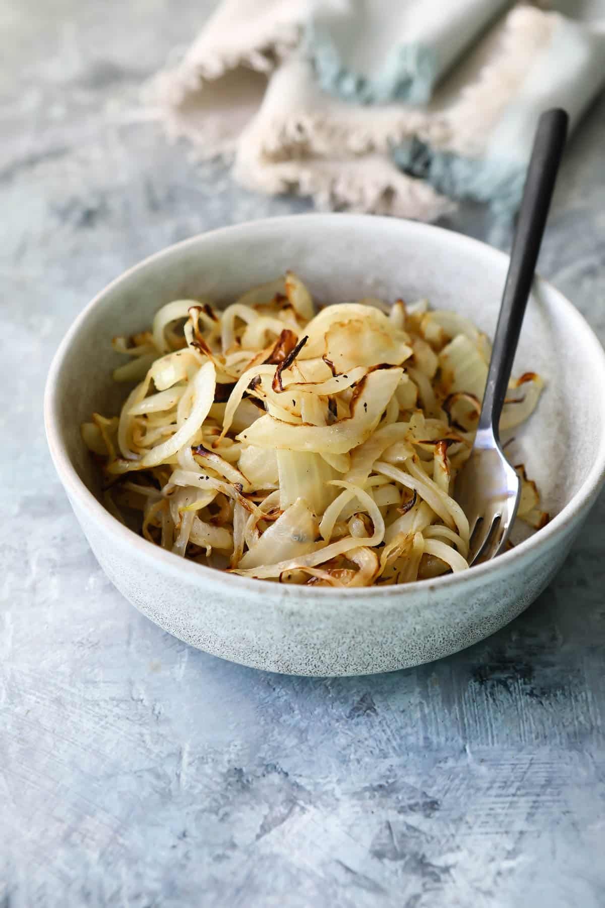 Air fryer onions in a small gray bowl.