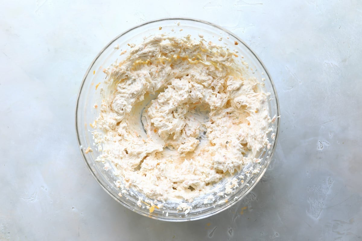 Beer cheese dip after being mixed in a clear bowl.
