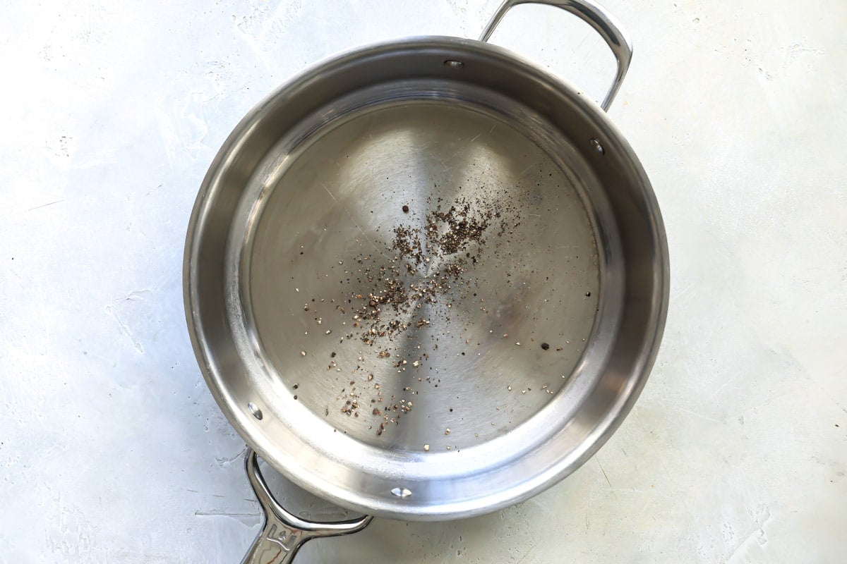 Course black pepper in a skillet.