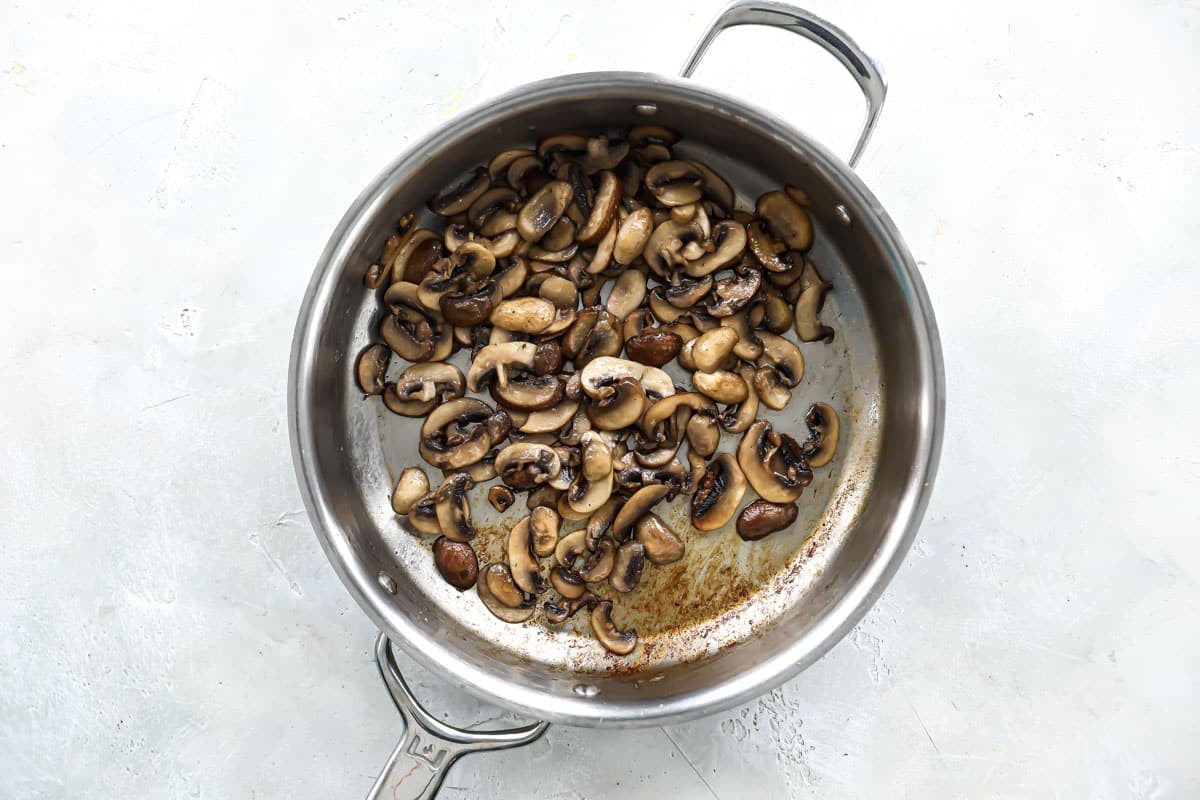 Mushrooms being cooked in a skillet for mushroom gravy.