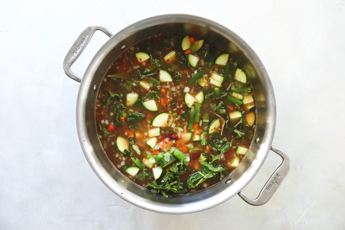 Copycat Olive Garden minestrone in a silver stockpot before simmering.