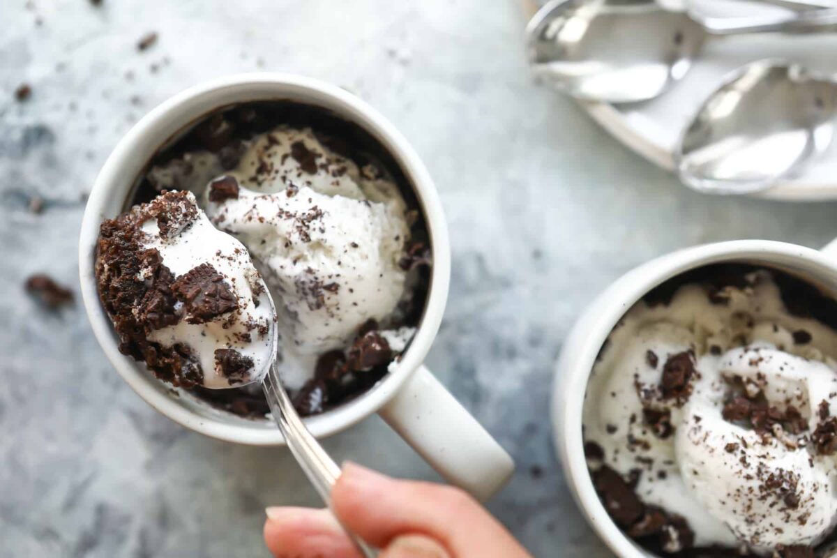 Someone taking a spoonful out of an oreo mug cake.
