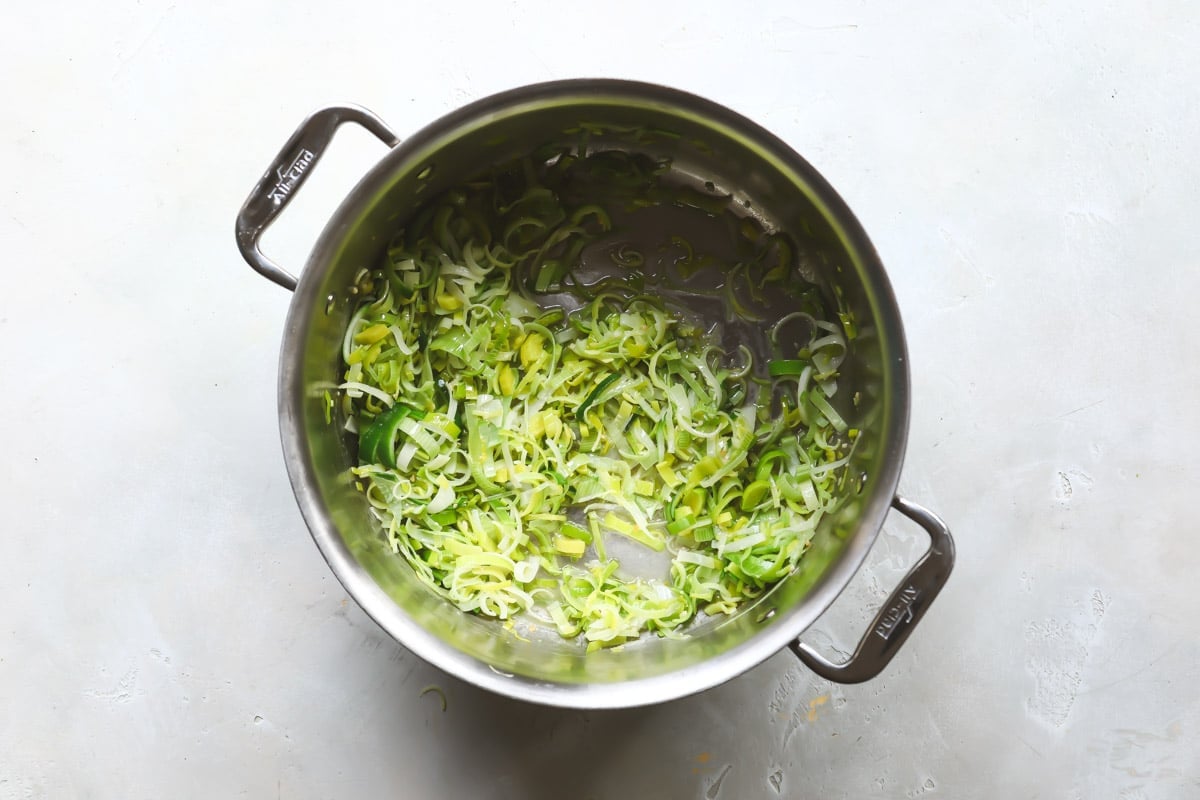 Shredded leeks in a silver pot.