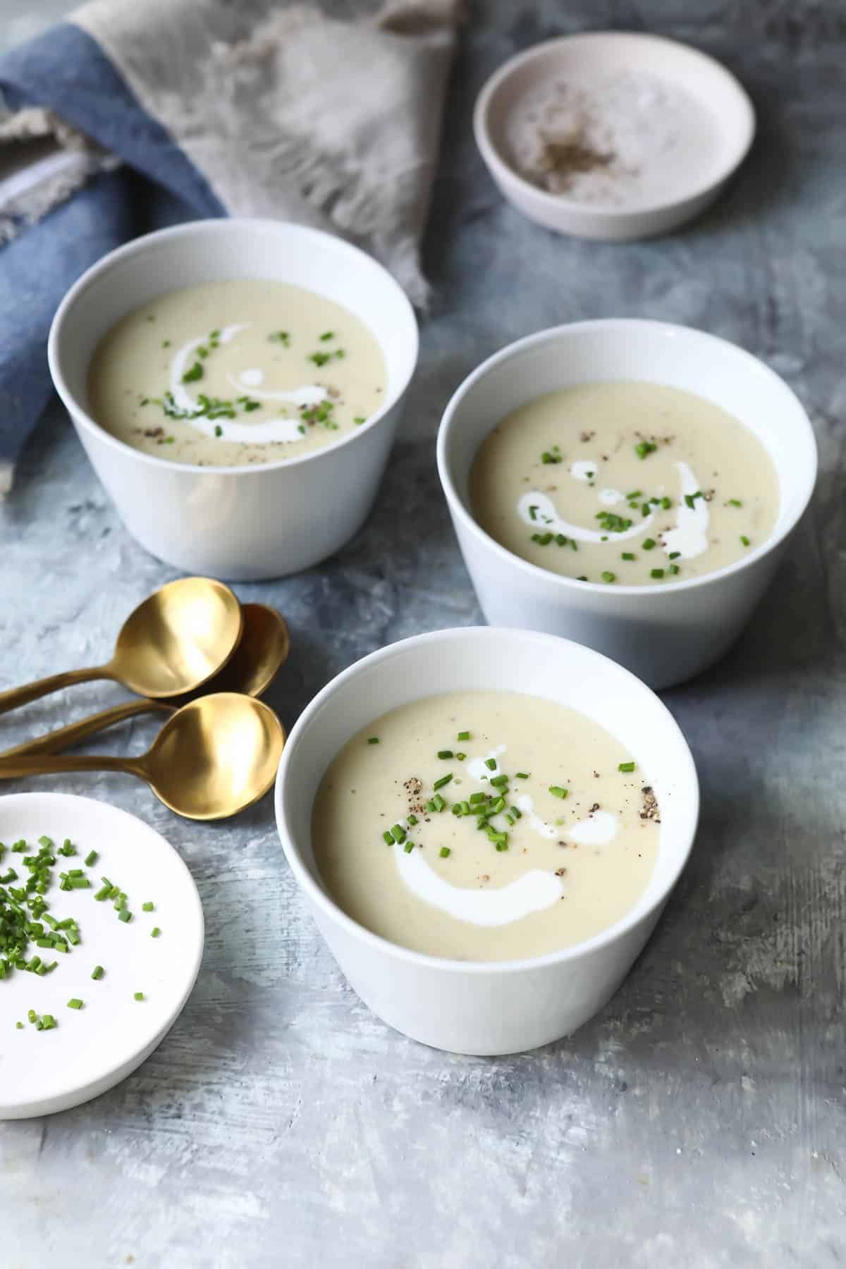 Three bowls of potato leek soup on a countertop.