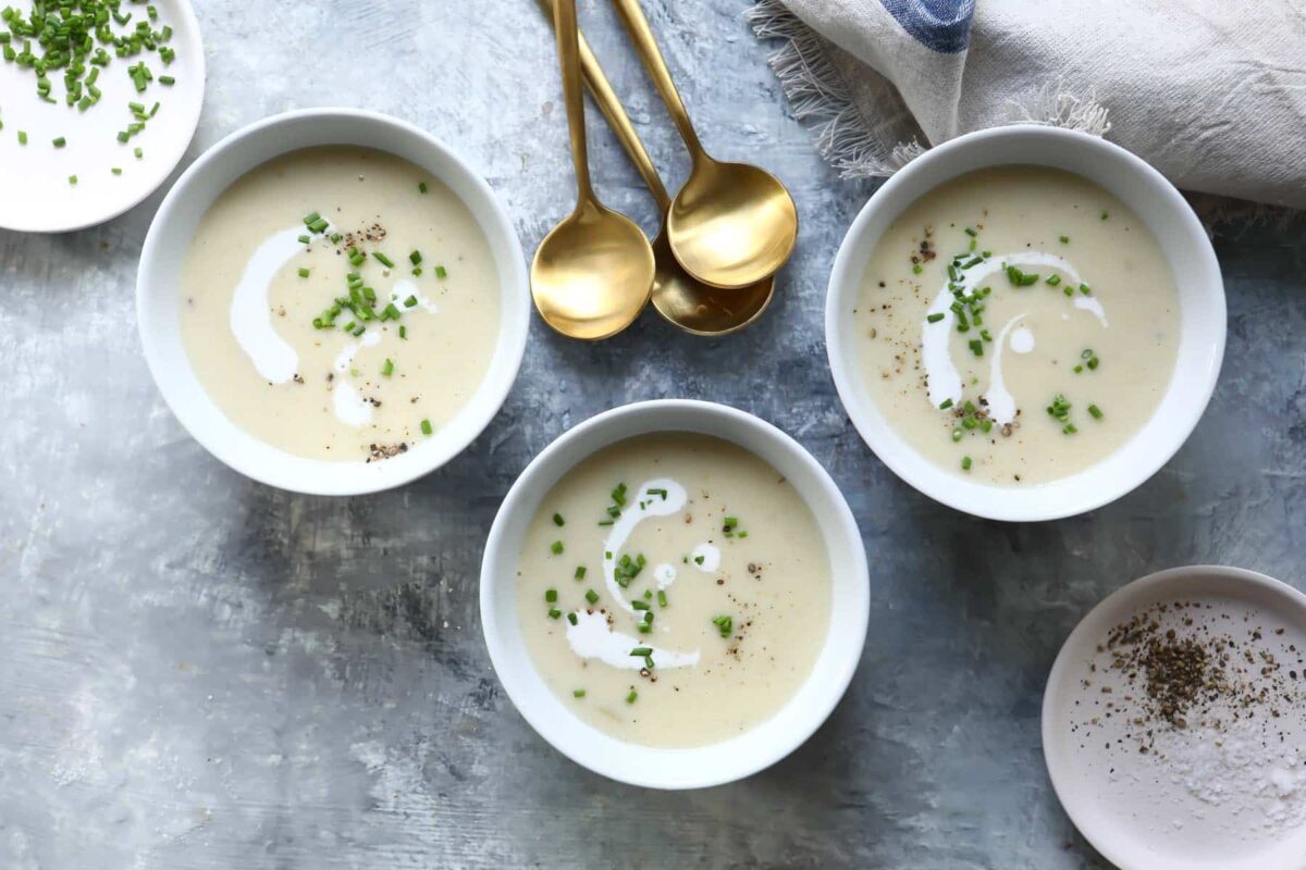 Three bowls of potato leek soup on a countertop.