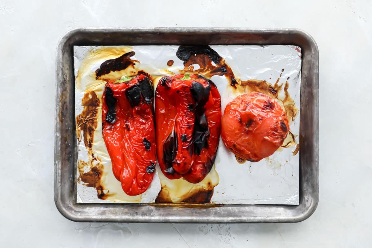 Roasted pepper and tomatoes on a baking sheet.