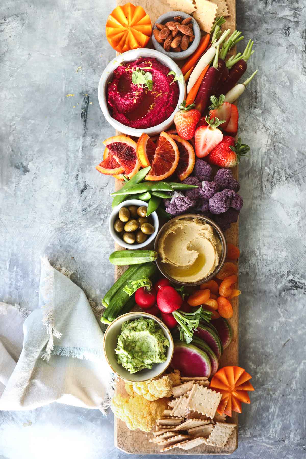 A vegan charcuterie board on a gray countertop.