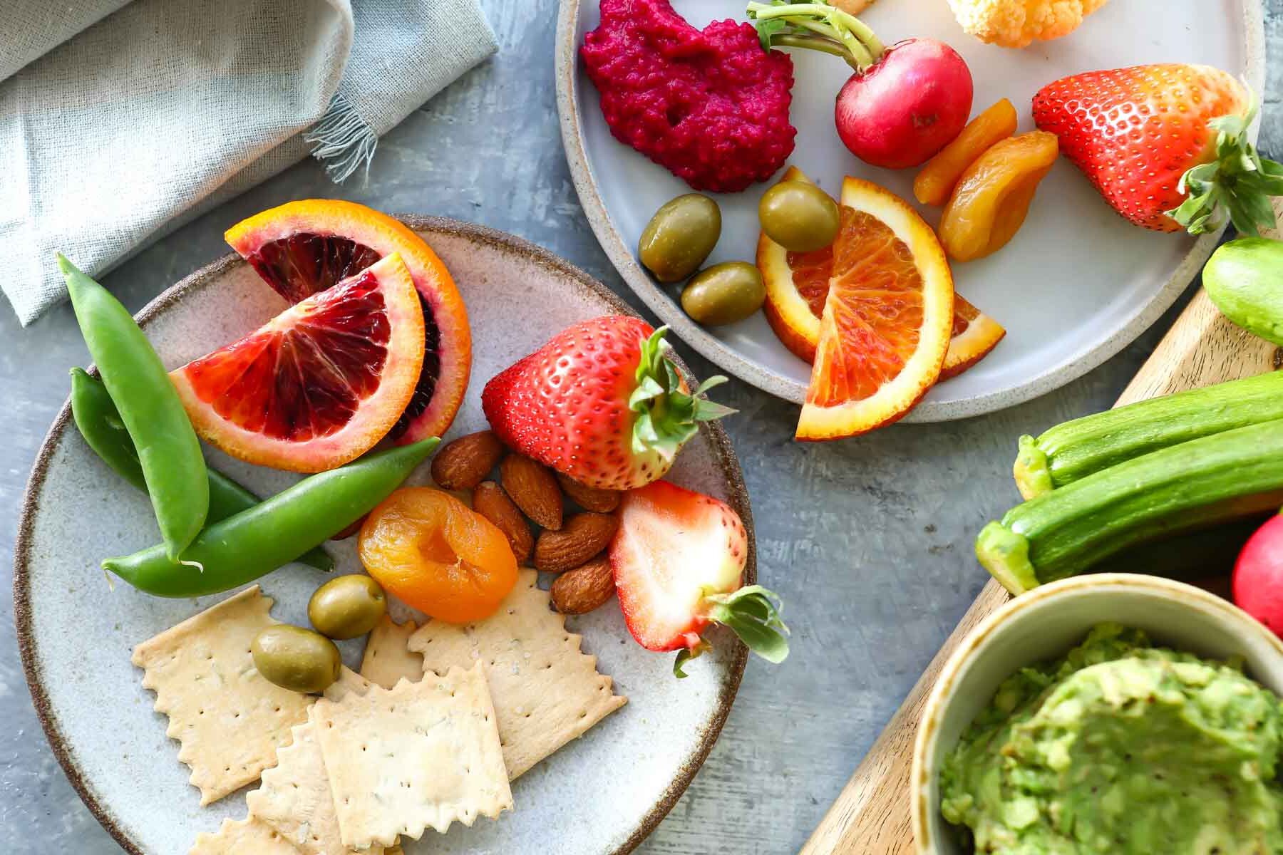 Two plates with items from a vegan charcuterie board.