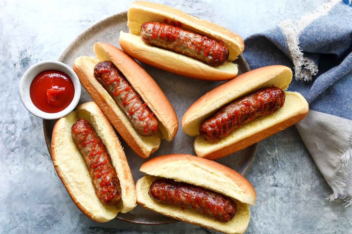 Air fryer sausages in buns with ketchup.
