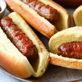 Air fryer sausages in buns with ketchup.