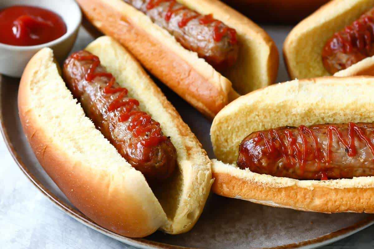 Air fryer sausages in buns with ketchup.