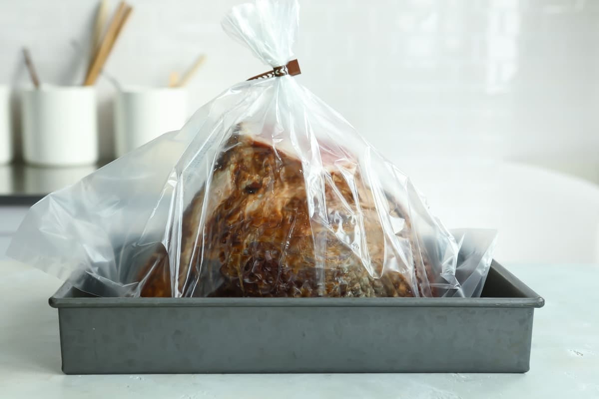 A sliced ham in a plastic oven bag.