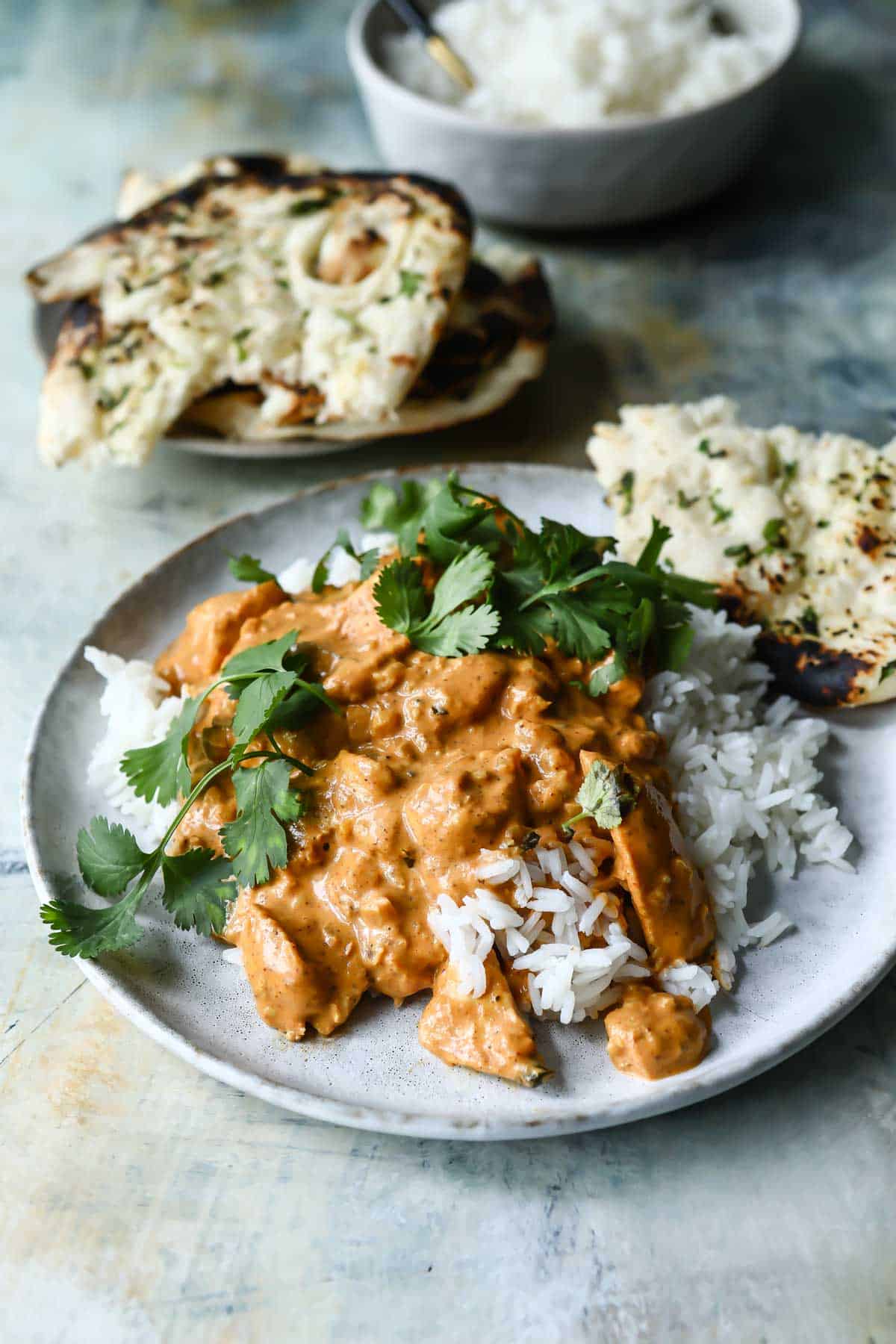 A plate of butter chicken over basmati rice.