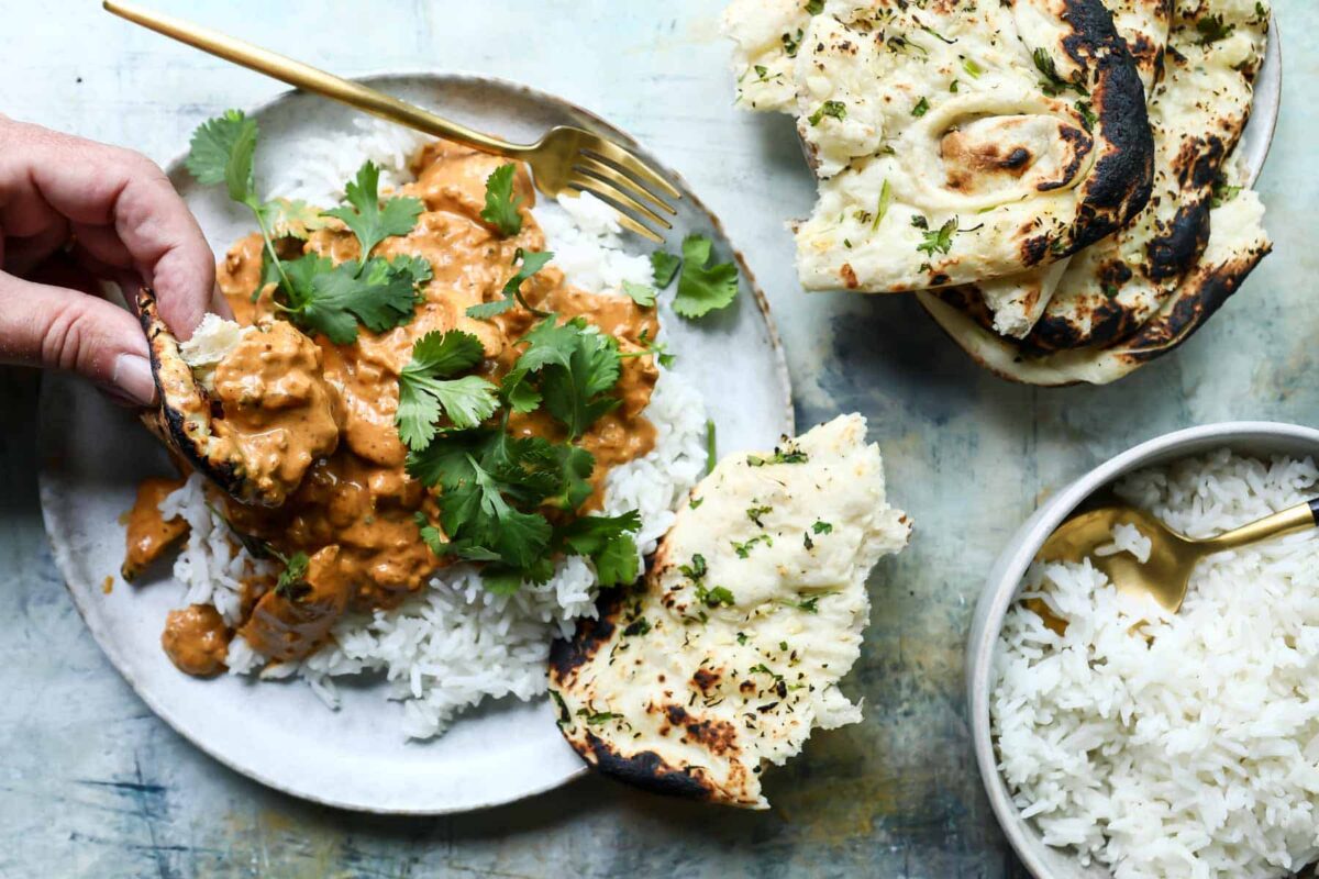 A plate of butter chicken over basmati rice.