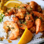 A plate of cajun shrimp, white rice, and corn on the cob.