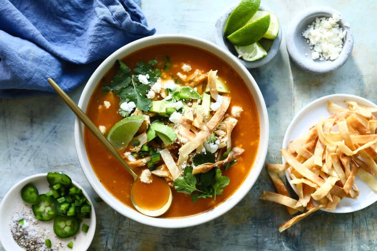 Bowls of chicken tortilla soup with all the garnishes.