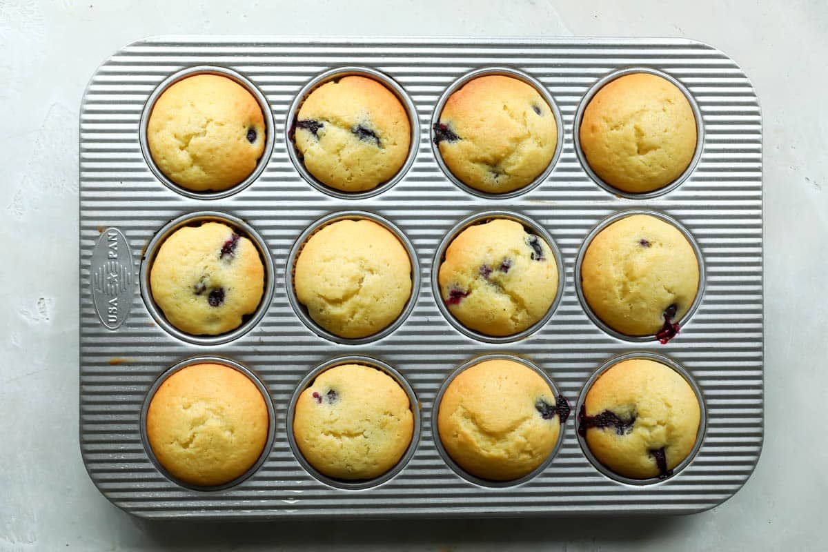 Lemon blueberry muffins baked in a muffin pan.