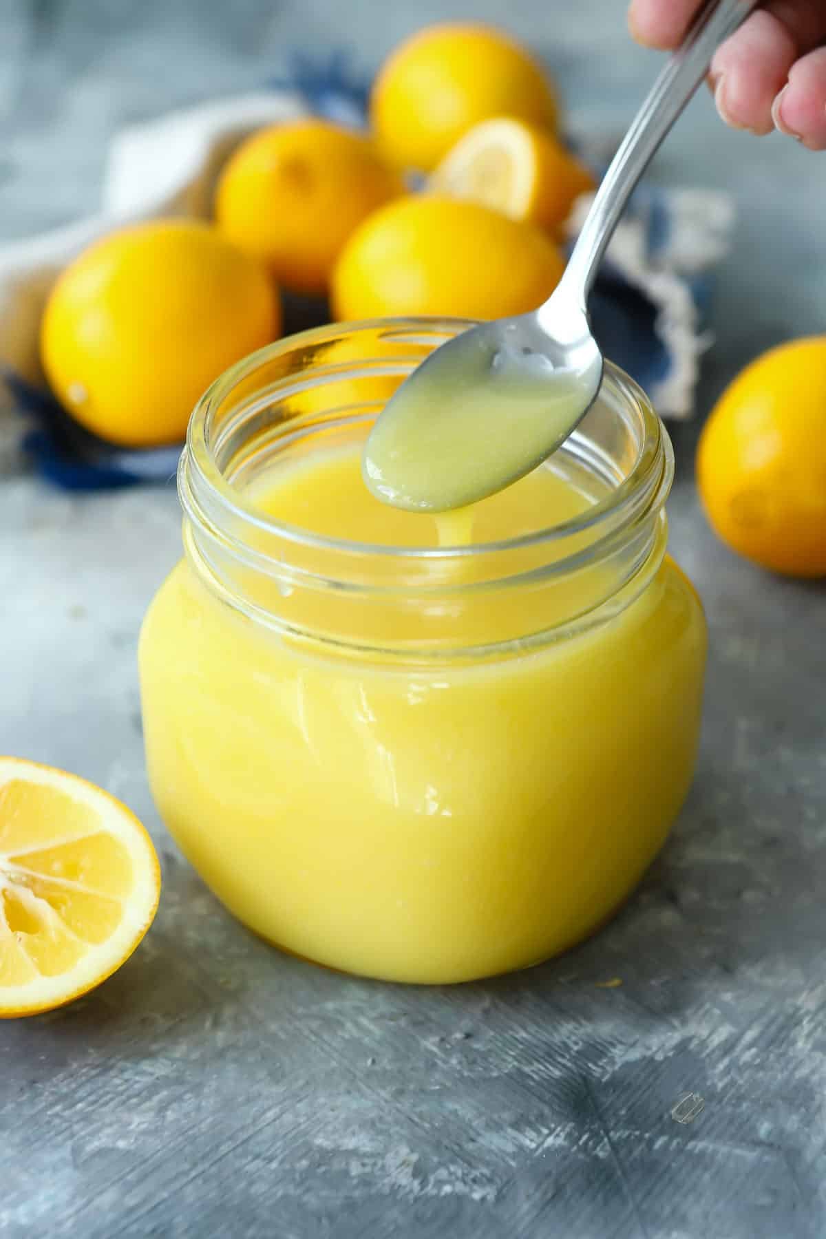 Lemon curd in a clear glass jar.