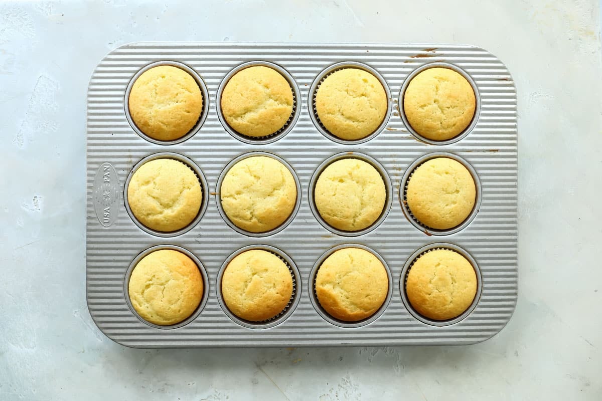 Lemon muffins in a muffin tin.