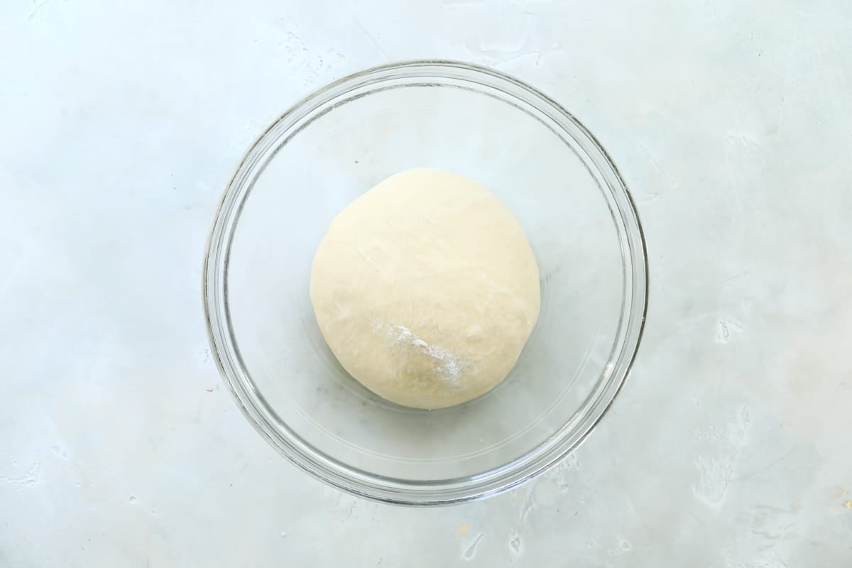 Dough for soft yeast dinner rolls in a large glass bowl before it has had time to rise.