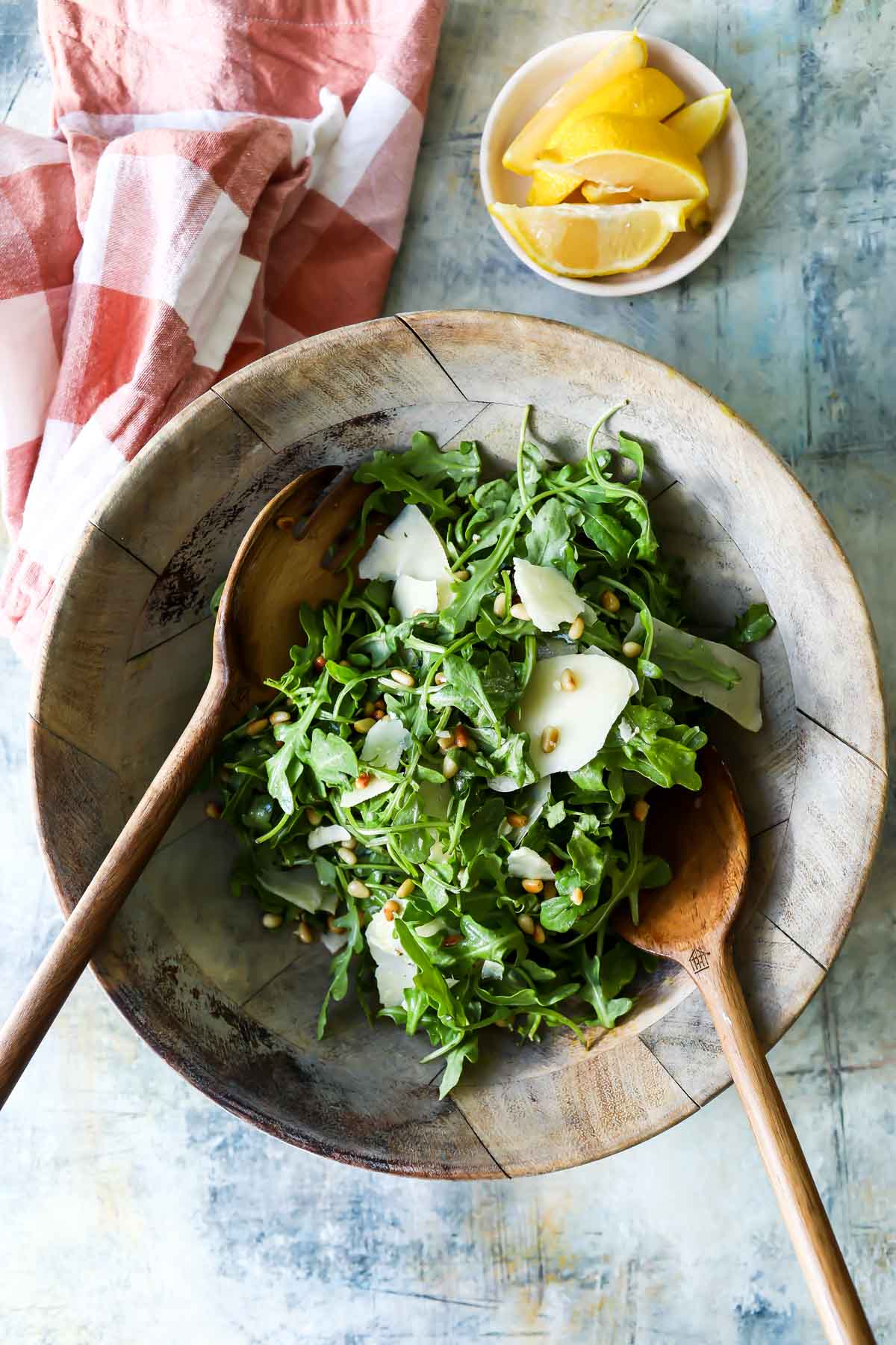 A bowl of arugula salad with pine nuts.