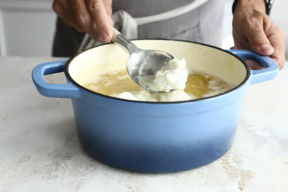 Skimming foam off chickpeas as they cook.