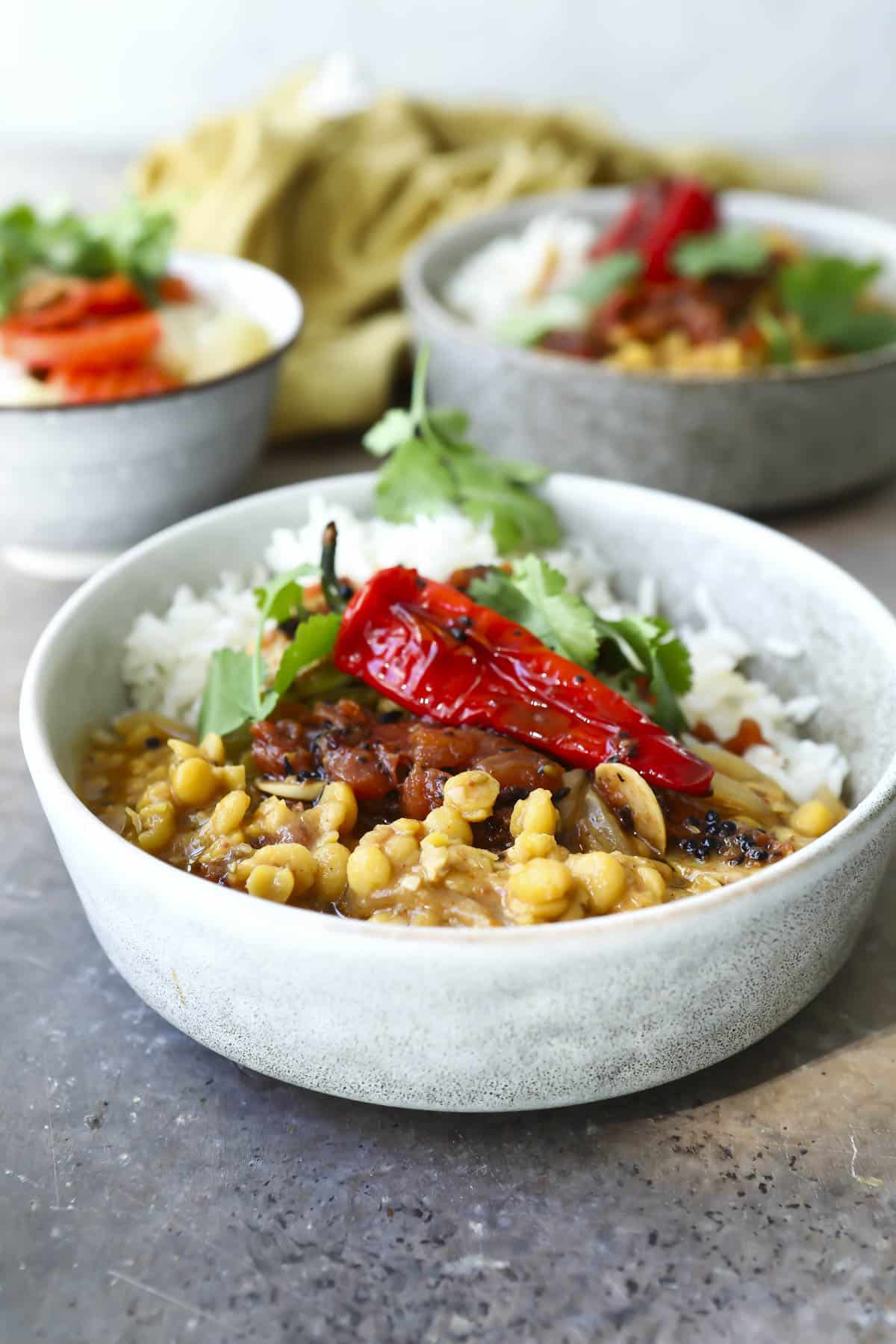 A bowl of chana dal with tadka and rice.
