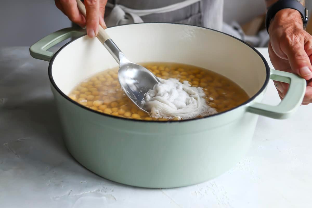 Skimming the foam off cooking chickpeas.