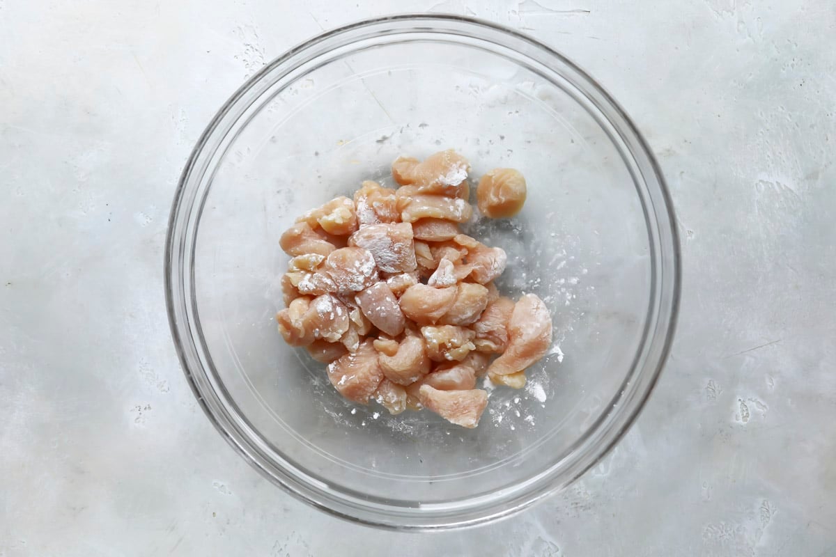 A bowl of chicken with baking soda for the velveting technique.
