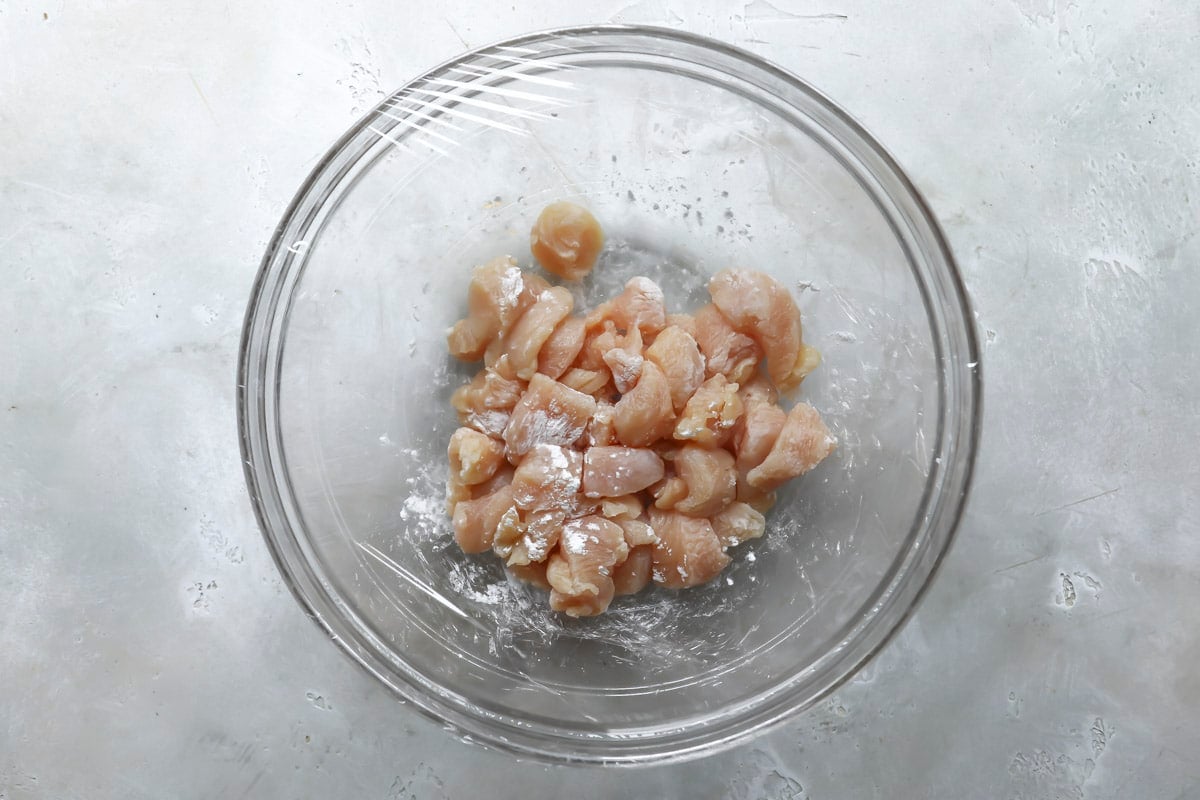 A bowl of chicken with baking soda for the velveting technique.