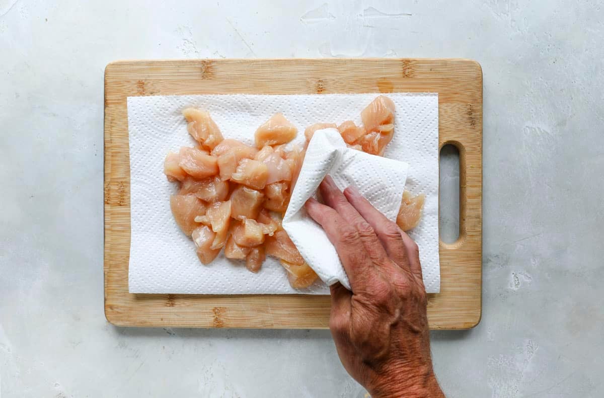 Patting chicken dry.