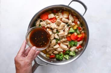 A skillet full of chicken stir fry.