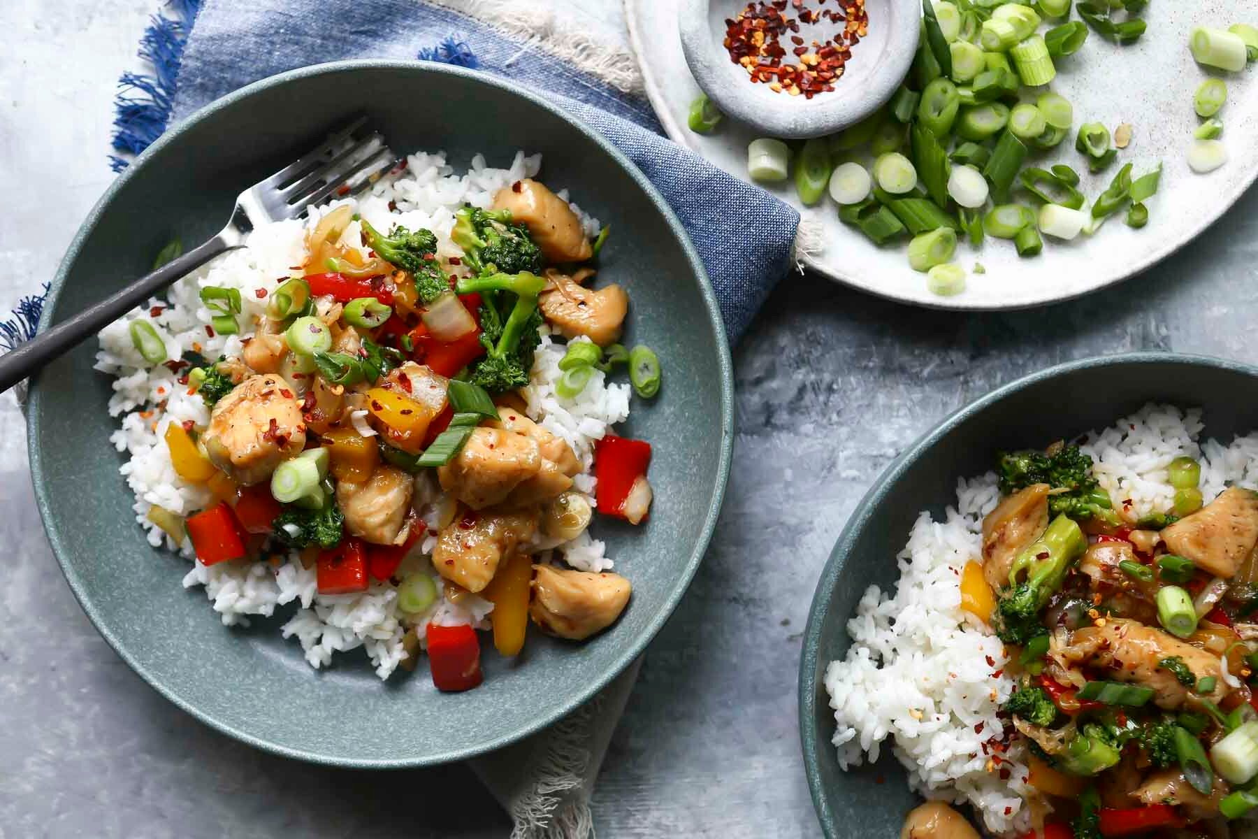 A bowl of homemade chicken stir fry with white rice.