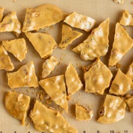 A silicone mat full of shards of peanut brittle.