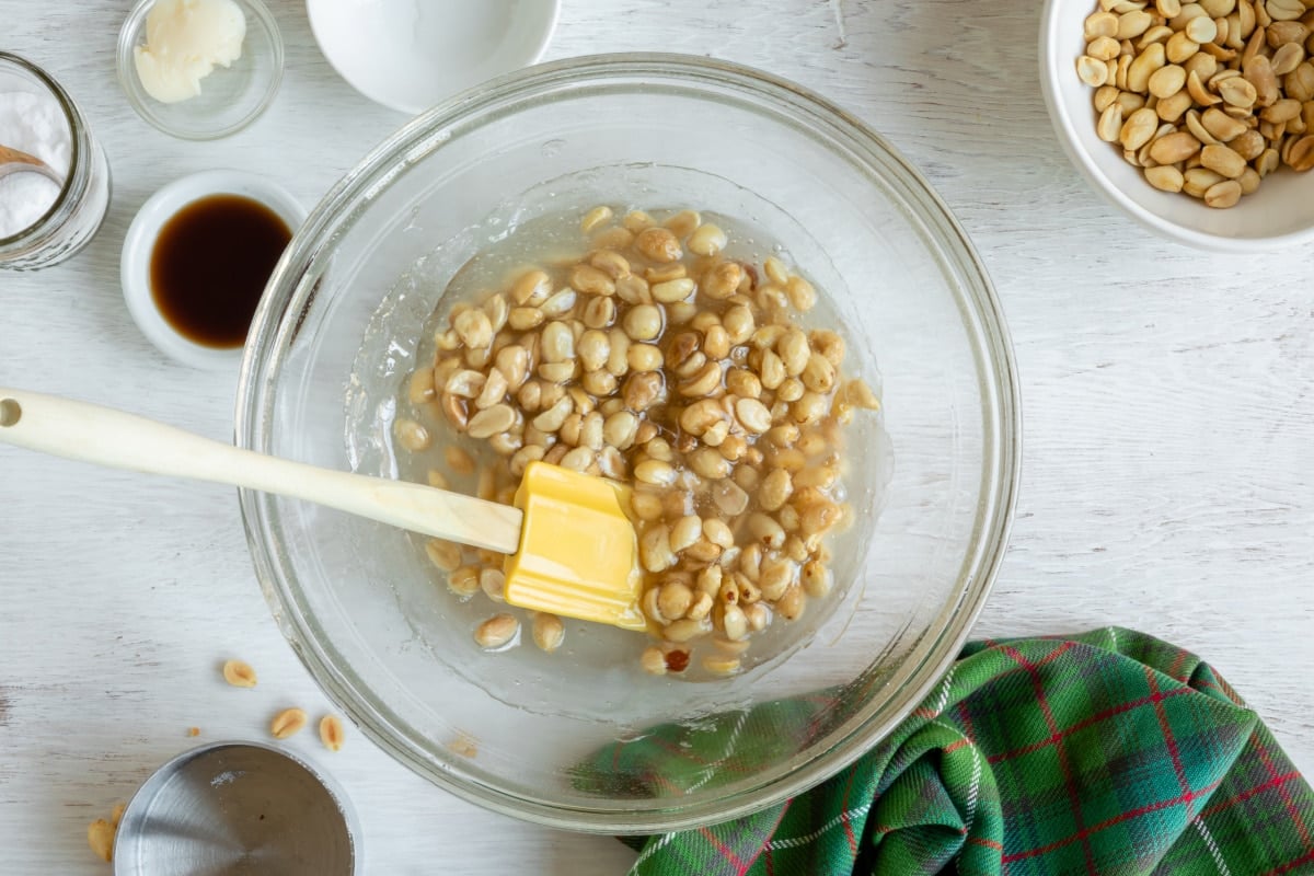A bowl of sugar and corn syrup with peanuts stirred in.