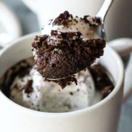 Two Oreo mug cakes topped with a whole oreo.