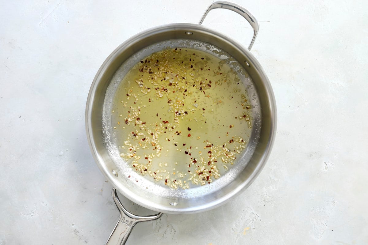 Red chili flakes, garlic, olive oil and butter in a skillet.