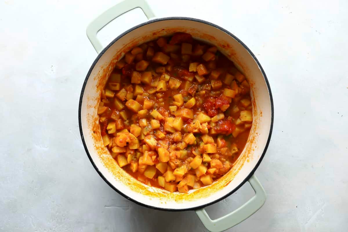 Adding potatoes to the pot for potato curry.