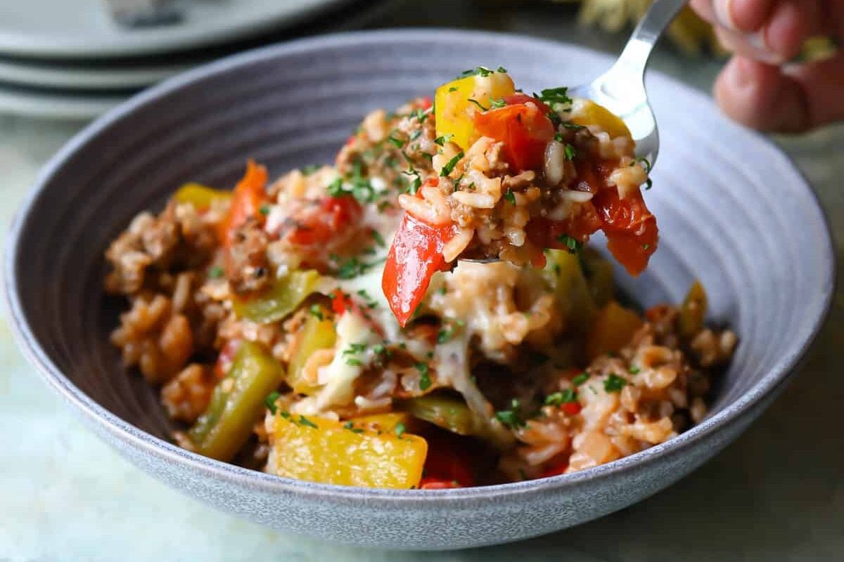 Someone scooping a spoonful of stuffed pepper casserole out of a bowl.