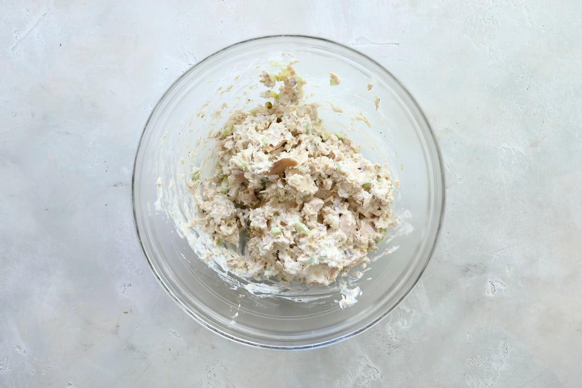 Tuna salad in a clear mixing bowl.