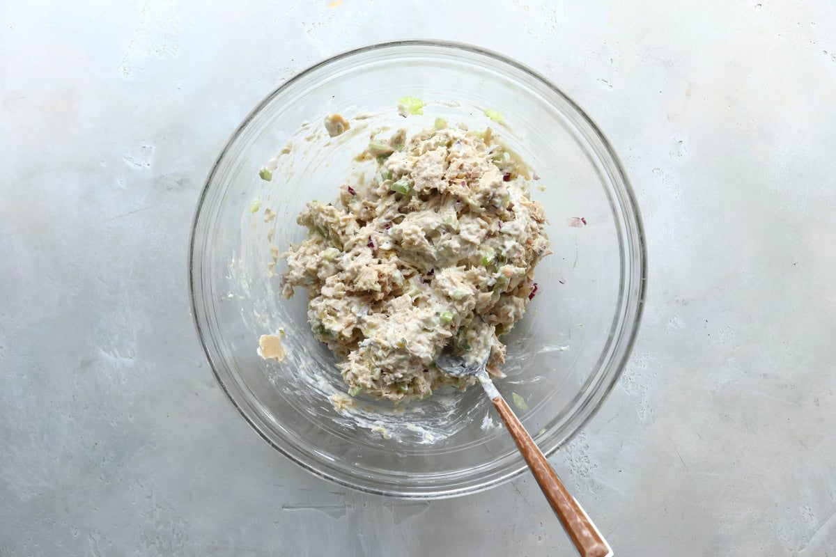 Tuna salad in a clear mixing bowl.