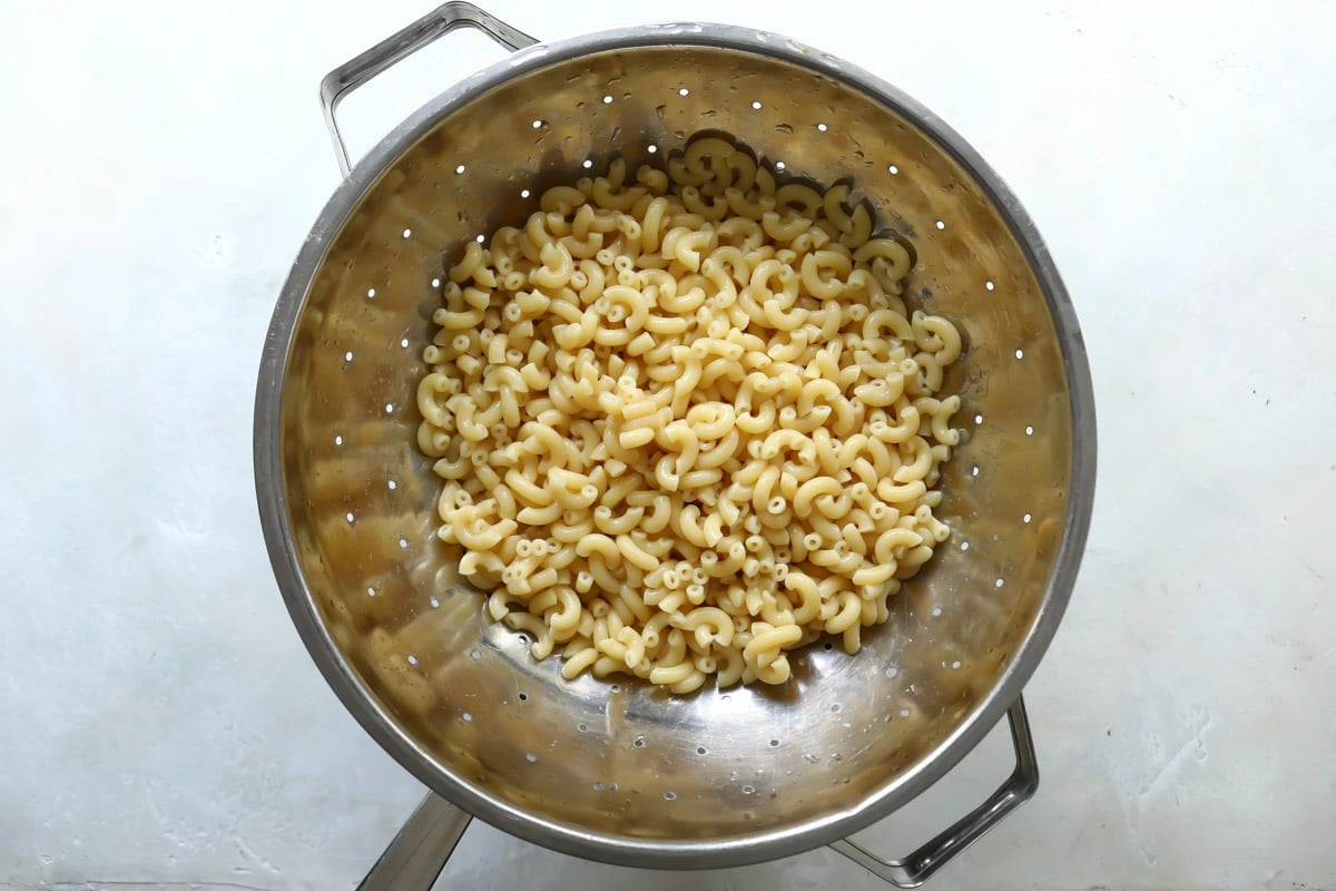 Cooked elbow macaroni in a colander.