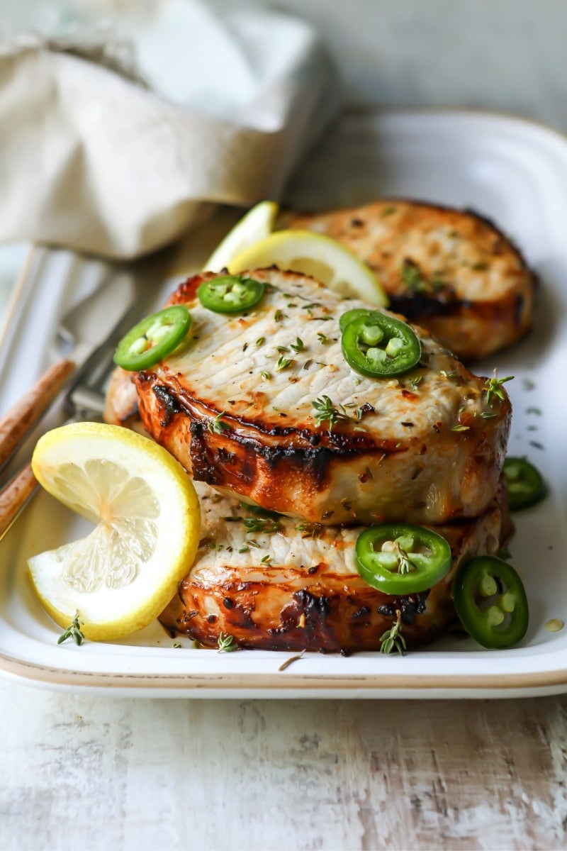 Air fryer pork chops on a white platter.